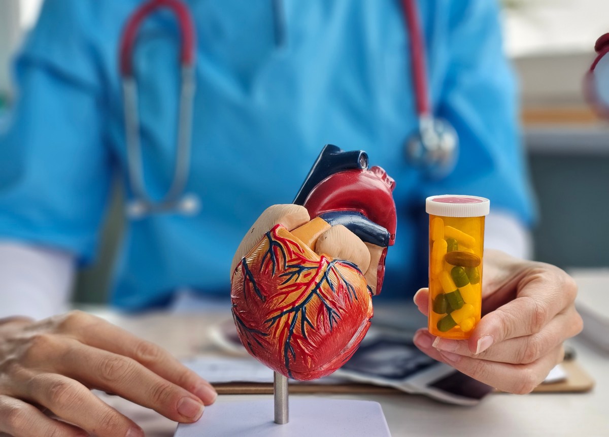 Una persona sosteniendo un frasco de medicamentos con una expresión de preocupación, con un estetoscopio al fondo