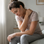 Persona con dolor en el cuerpo y fatiga, con una expresión de molestia