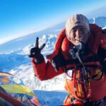Purnima Shrestha en la cima del Everest con una vista impresionante de los picos nevados