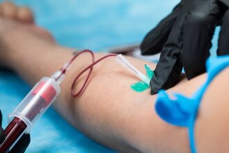 Un profesional de la salud sostiene un informe de laboratorio con gráficas y resultados de análisis de sangre.