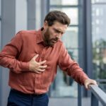 Persona con ansiedad y tensiómetro en mano, reflejando el impacto de la ansiedad en la salud cardiovascular