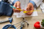 Un hombre y una mujer sosteniendo una prueba de embarazo positiva, con un fondo de un consultorio médico