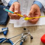 Un hombre y una mujer sosteniendo una prueba de embarazo positiva, con un fondo de un consultorio médico