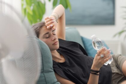 Persona bebiendo agua durante una jornada de calor extremo para prevenir daños renales