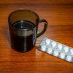Taza de café junto a pastillas, mostrando el riesgo de mezclar ambos en tratamientos médicos