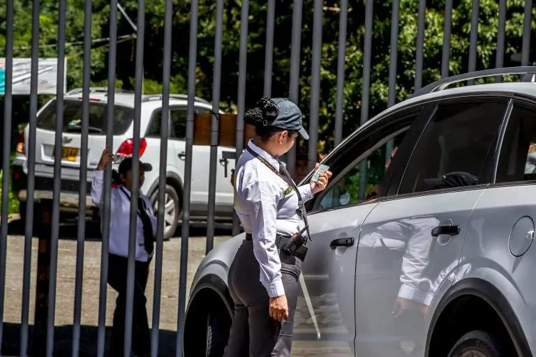 Personal de seguridad privada vigilando la entrada de un edificio público en Colombia